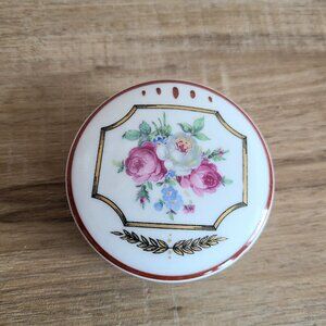 Vintage Limoges France porcelain round jewelry box with floral design.